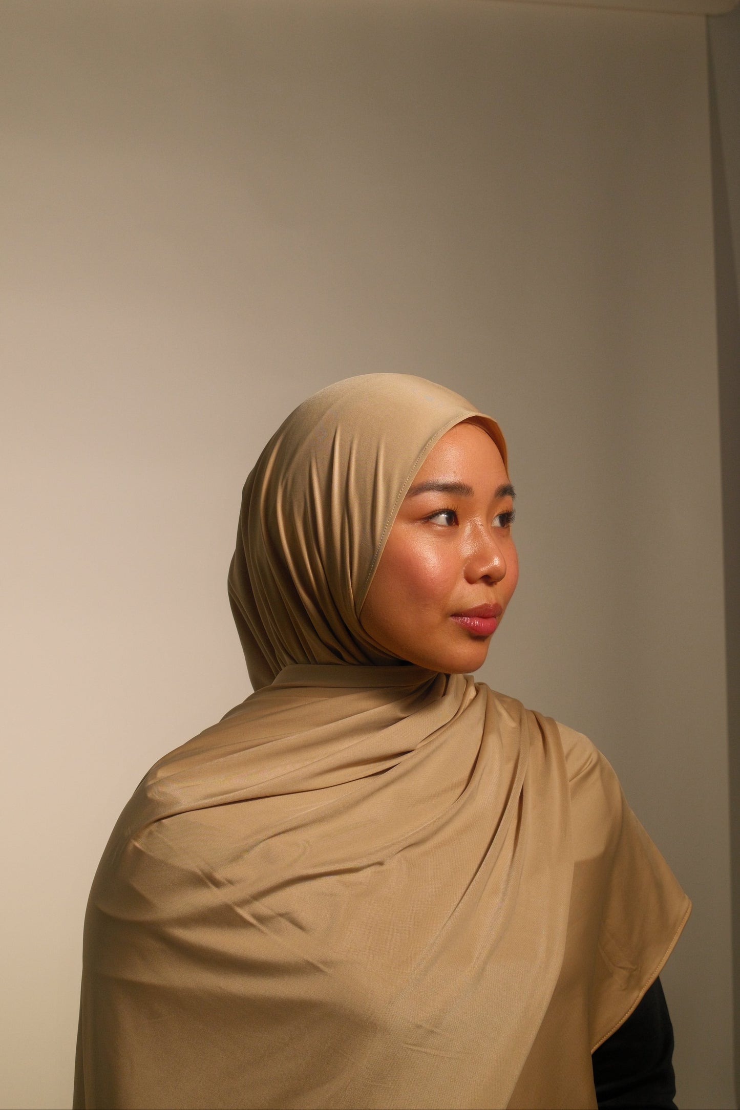 Hijabi women wearing beige liquid fluid jersey hijab by the brand malika the collection