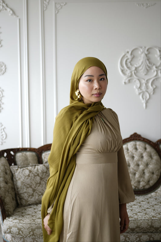 Women wearing the amina dress in the color soft sand and premium modal hijab in the color moss by the brand malika the collection