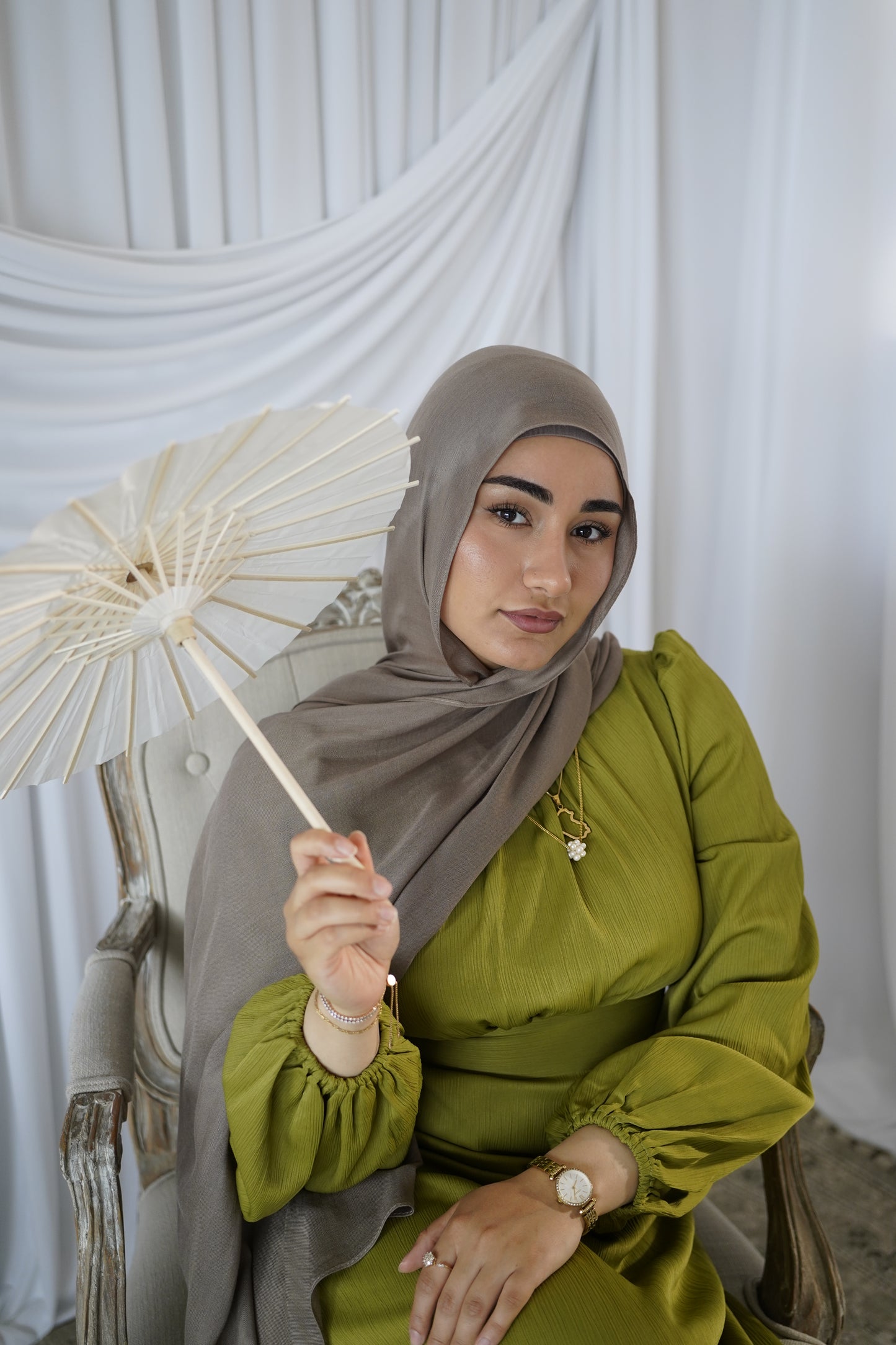 women wearing the amina dress in the color olive bloom and modal hijab in the color taupe by malika the collection. 