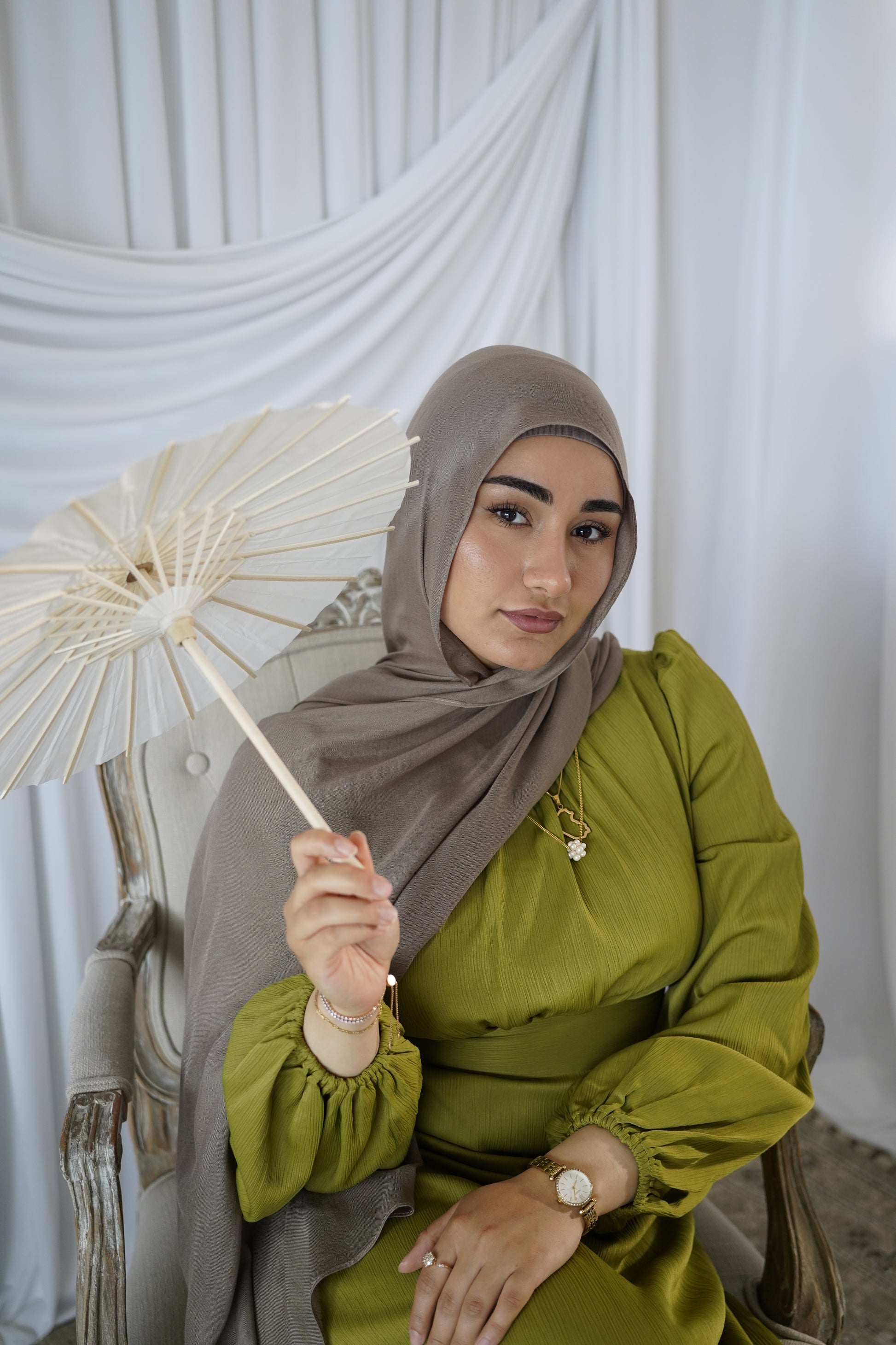 women wearing the amina dress in the color olive bloom and modal hijab in the color taupe by malika the collection. 