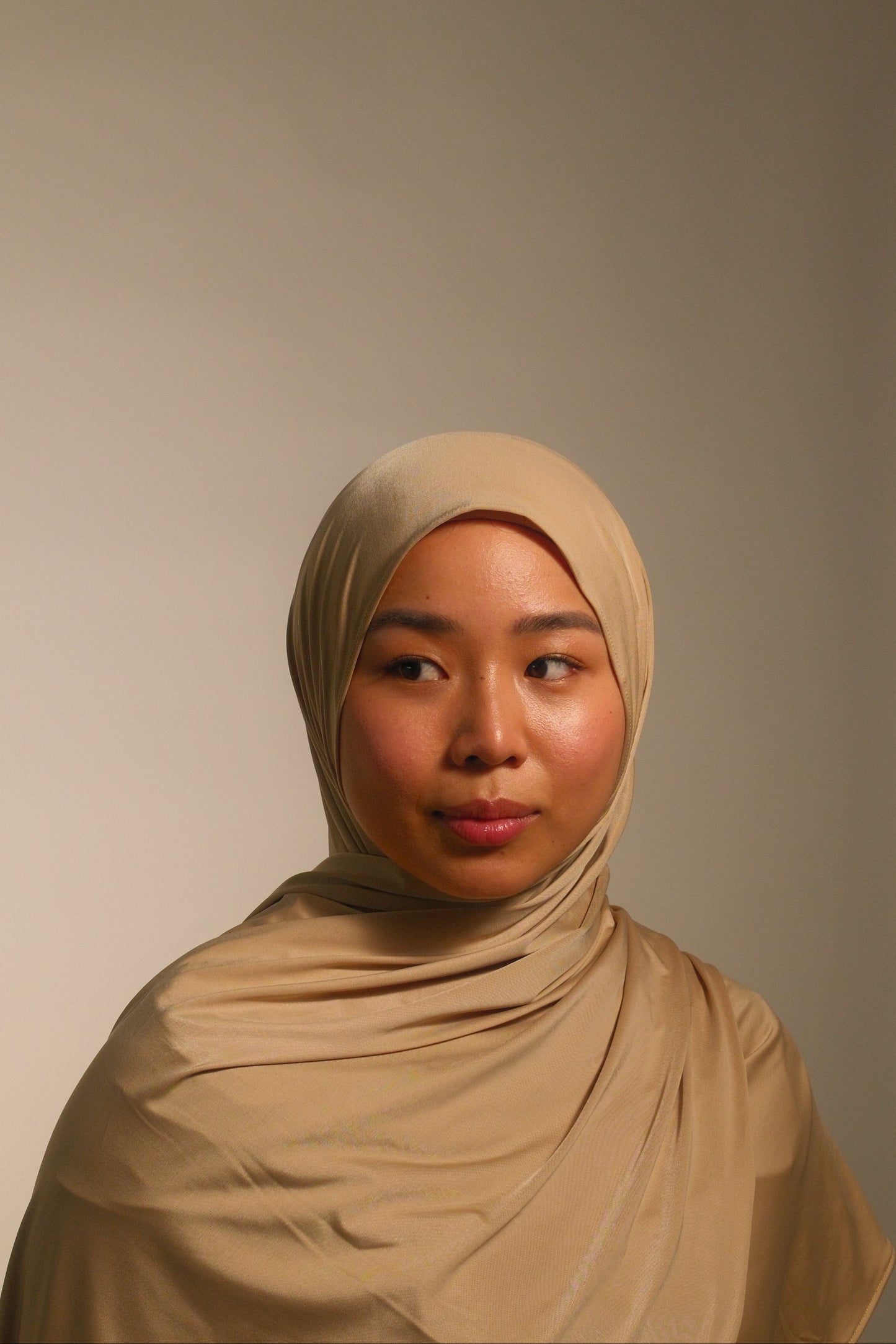 Hijabi women wearing beige liquid fluid jersey hijab by the brand malika the collection