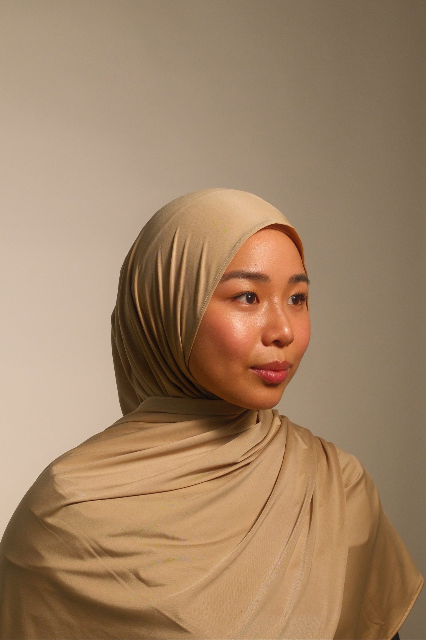 Hijabi women wearing beige liquid fluid jersey hijab by the brand malika the collection