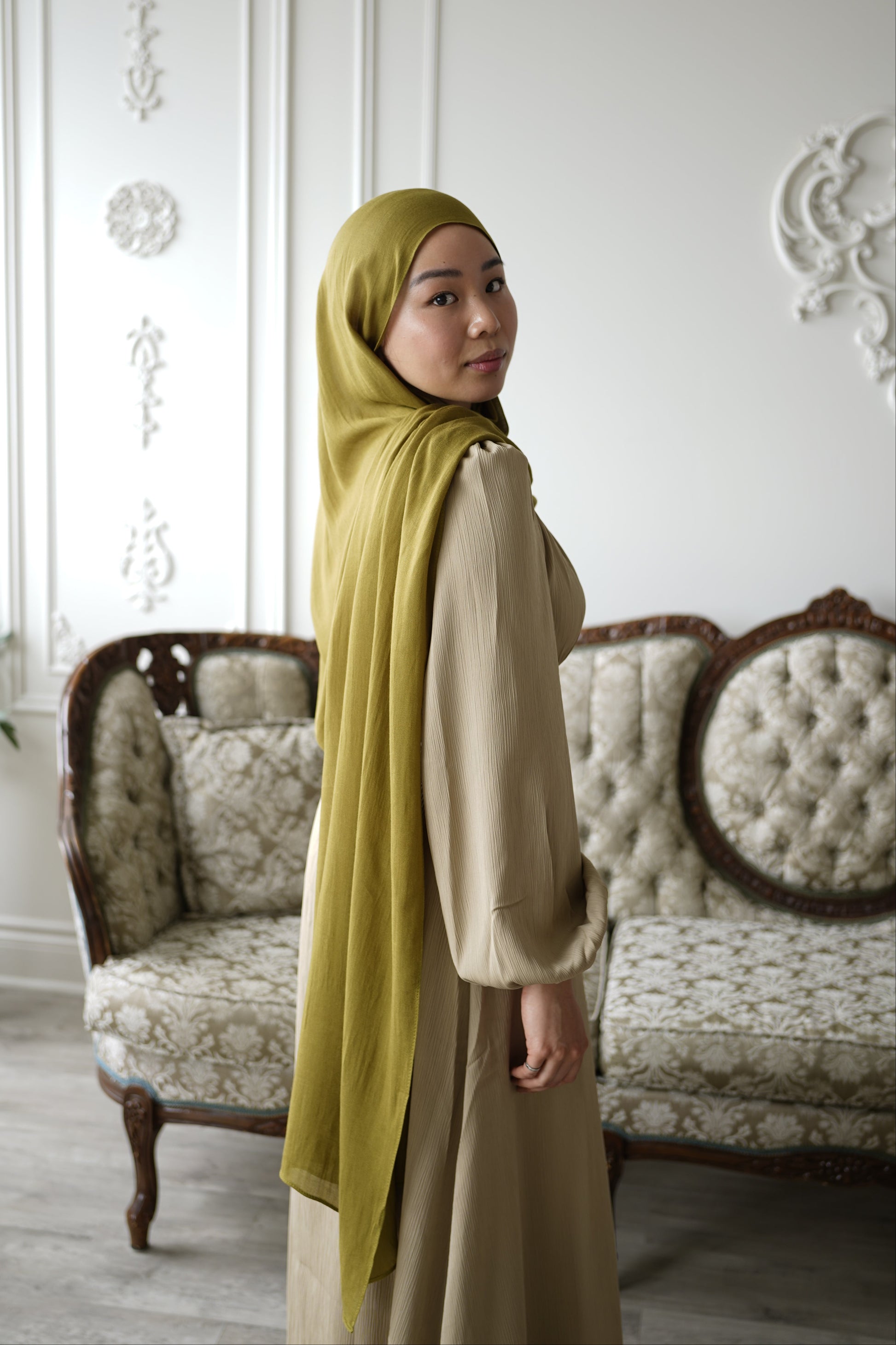 Women wearing the amina dress in the color soft sand and premium modal hijab in the color moss by the brand malika the collection