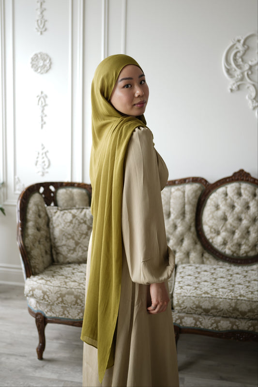 Women wearing the amina dress in the color soft sand and premium modal hijab in the color moss by the brand malika the collection