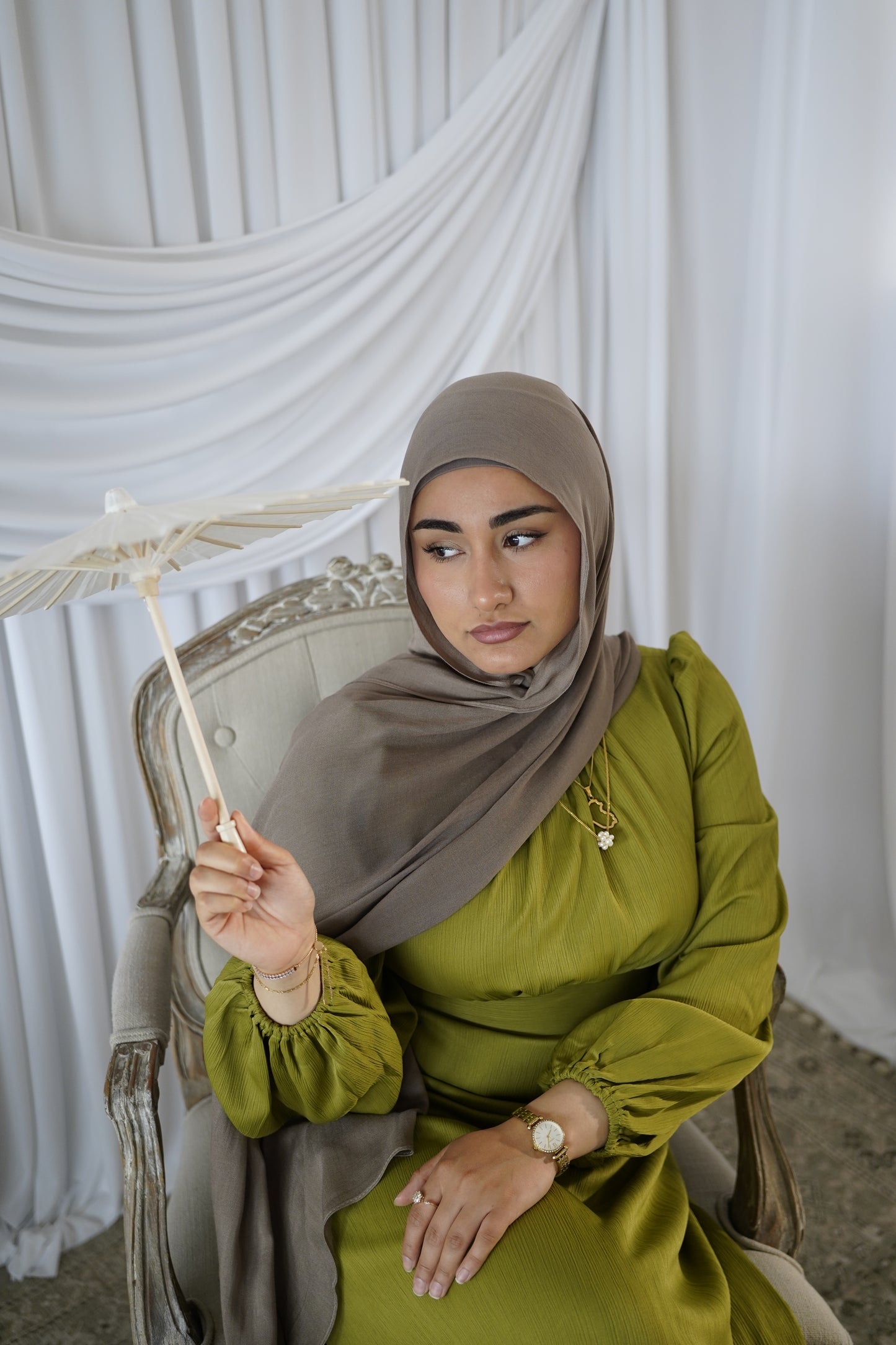 women wearing the amina dress in the color olive bloom and modal hijab in the color taupe by malika the collection. 